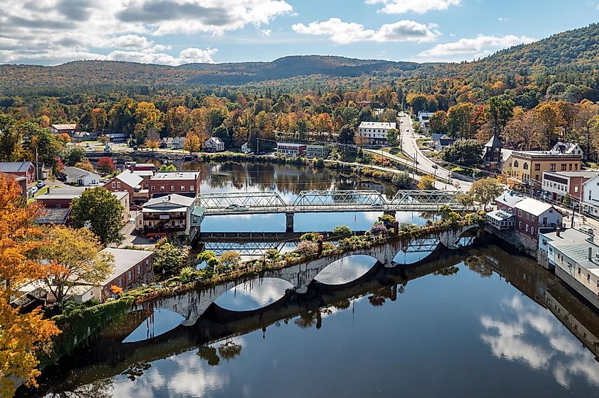 The Bridge of Flowers spans the Deerfield River with the rolling hills of Western Massachusetts as a backdrop in Shelburne, Massachusetts during fall.