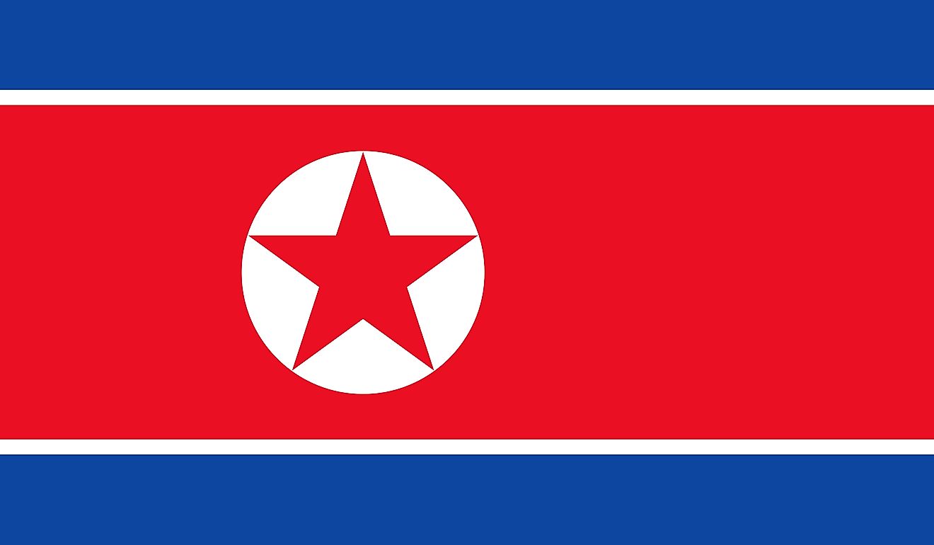 The flag of North Korea features three horizontal bands of blue (top), red (triple width and edged in white), and blue, and a white disk with five-pointed star on the hoist side of the red band