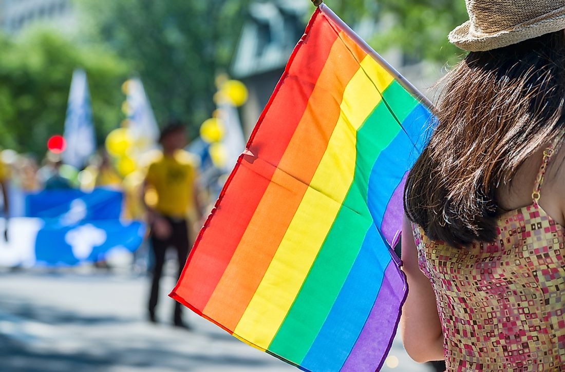 A spectator carries a pride flag at an event. 