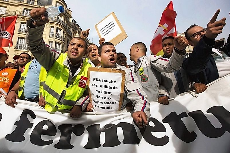 French workers protesting job cuts due to high labor tax costs at their places of employment.