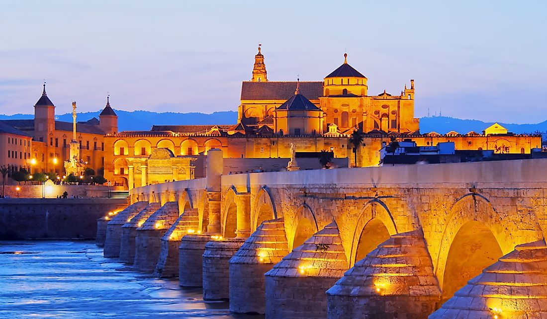Night view of the Mosque-Cathedral of Cordoba and the Roman bridge in Cordoba, Andalusia, Spain.