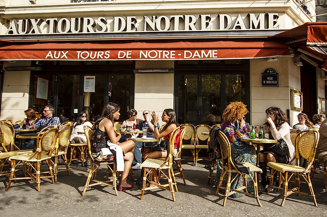 People sit in a cafe in Paris. Editorial credit: Rrrainbow / Shutterstock.com.