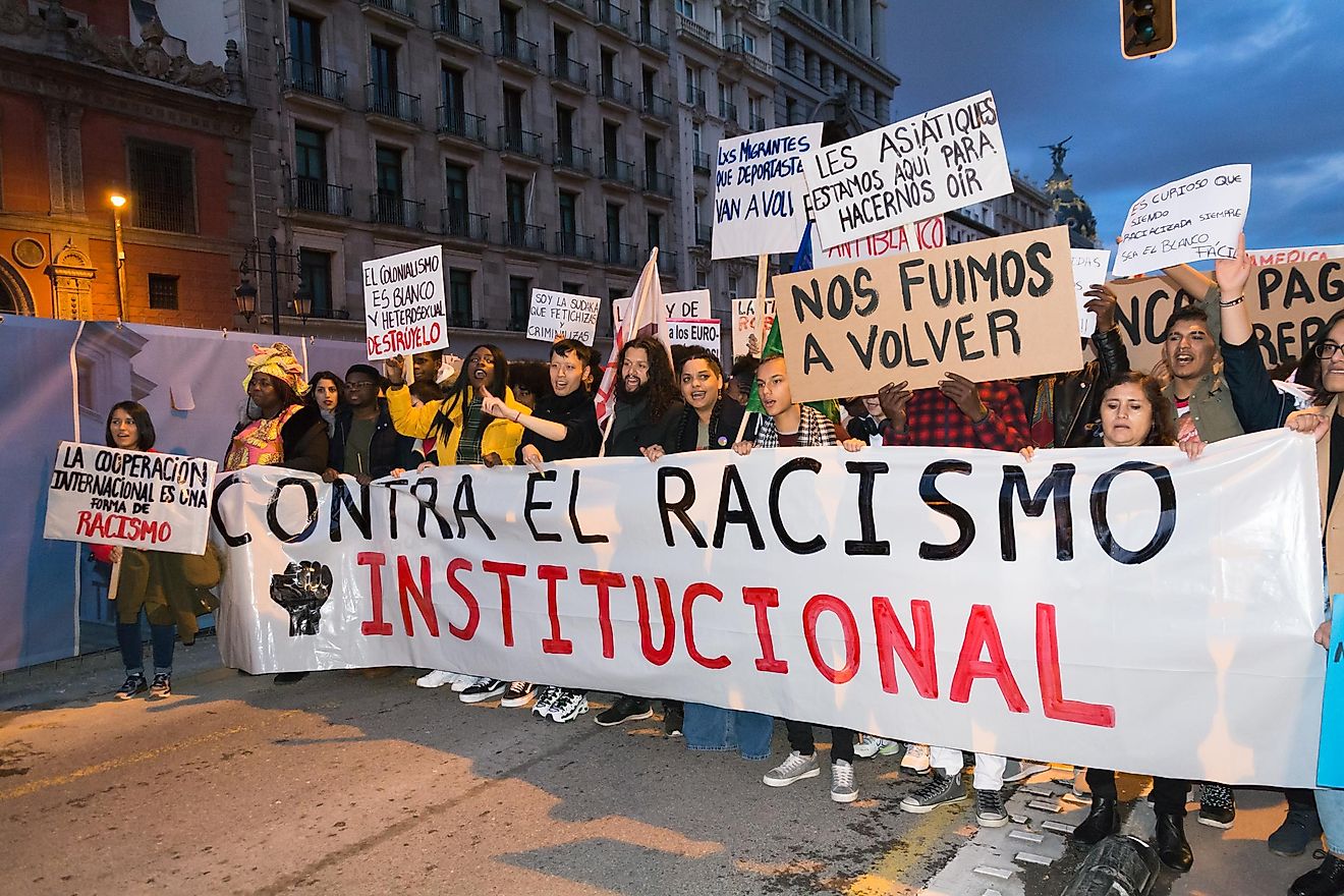 Protestors in Madrid hold up a sign protesting systemic racism. Editorial credit: Magdalena Rydz / Shutterstock.com