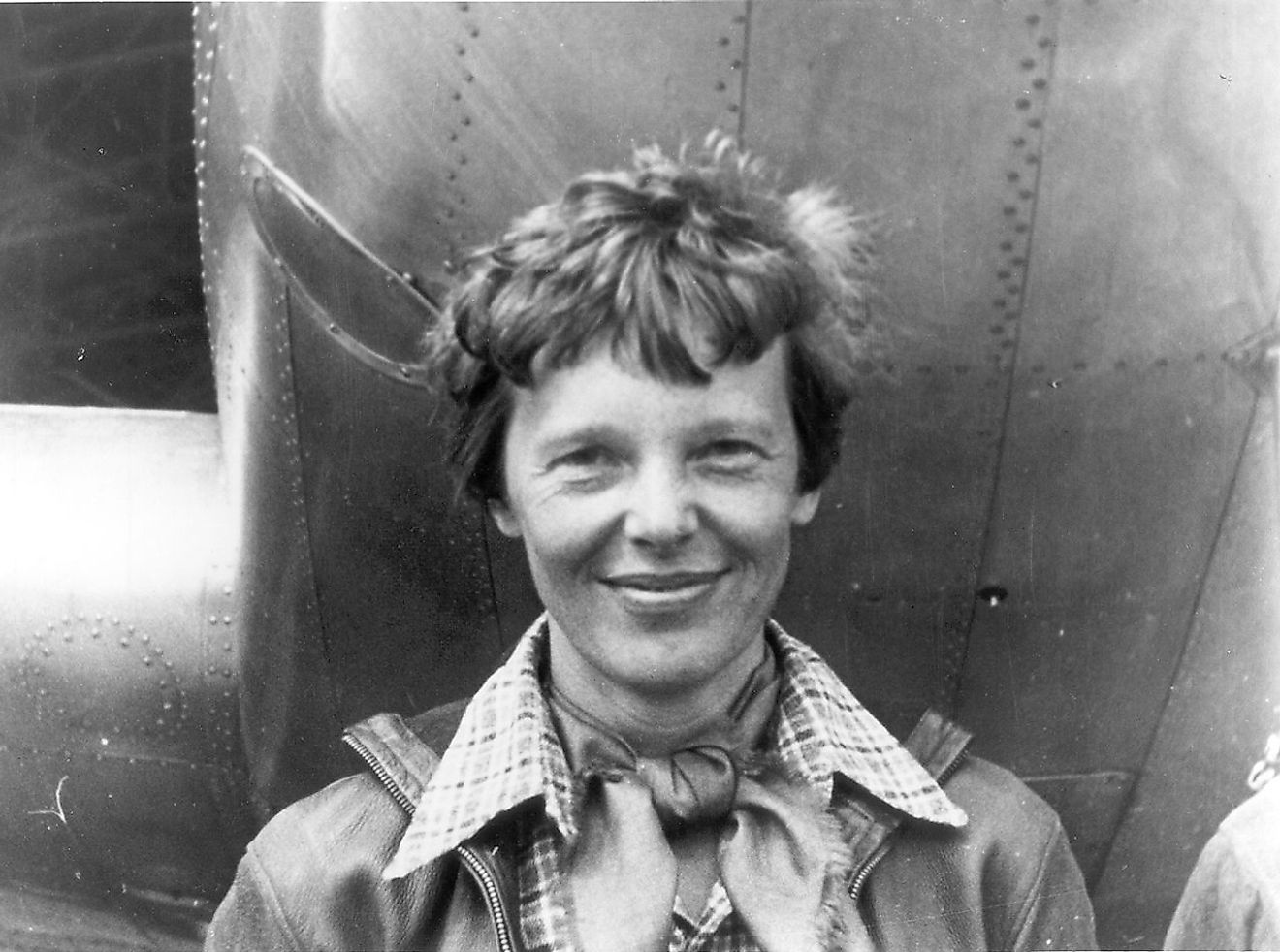 Amelia Earhart standing under nose of her Lockheed Model 10-E Electra. Gelatin silver print, 1937.
