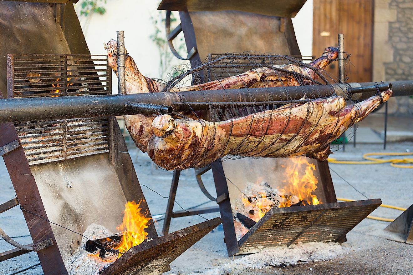 Carcass of whole bull roasting on spit at Medieval Fiesta in Besalu, Spain. Image credit: Iakov Filimonov/Shutterstock.com