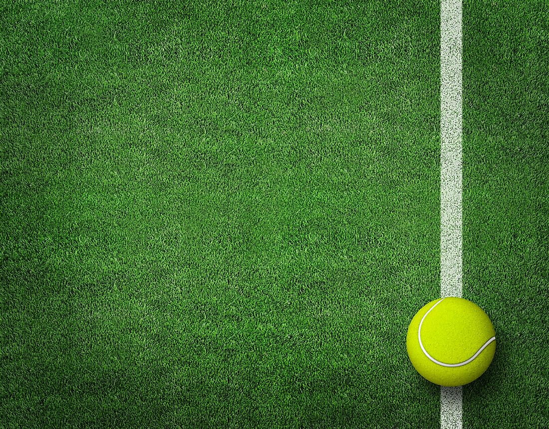 A tennis ball on a grass tennis court. 