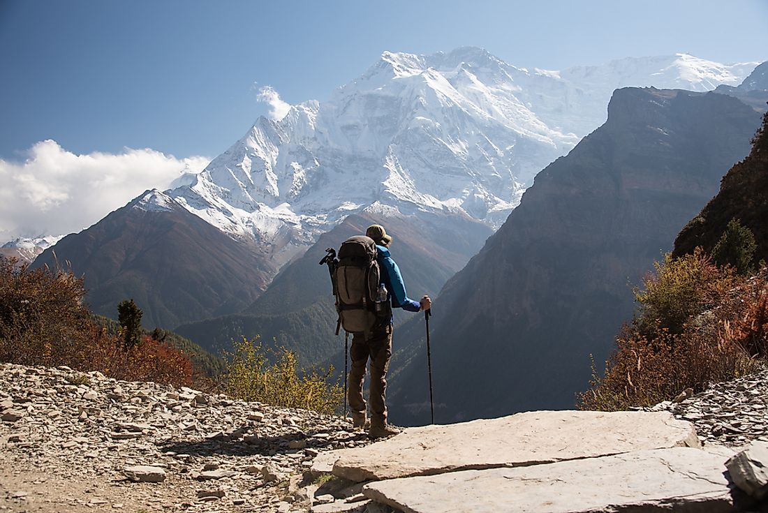 A backpacker stands overlooking the mountains in Nepal. 