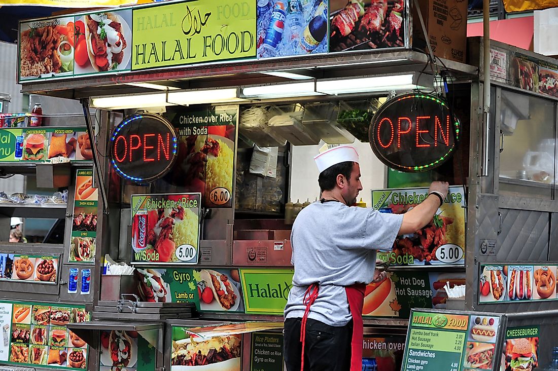 A food stall in New York advertising Halal food. Editorial credit: ChameleonsEye / Shutterstock.com.