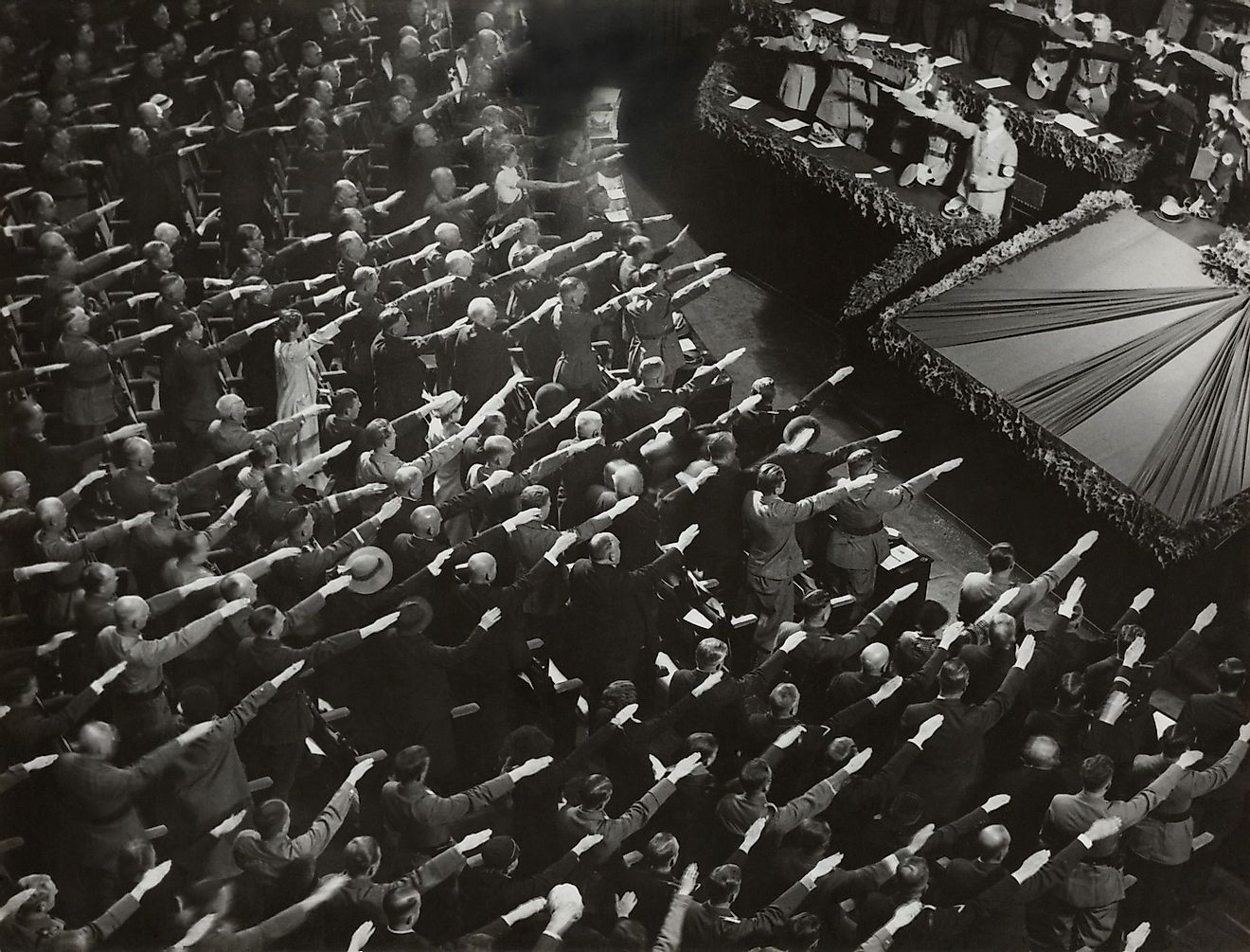 Attendees give Hitler the Nazi salute during the nation anthem, Oct. 9, 1935. They were meeting at the Kroll Opera in Berlin. Editorial credit: Everett Collection / Shutterstock.com