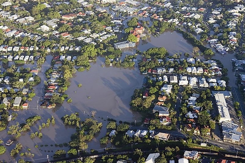As climate change intensifies, coastal flooding, such as the pictured event in Brisbane, Australia from 2011, threatens to displace hundreds of millions of people.
