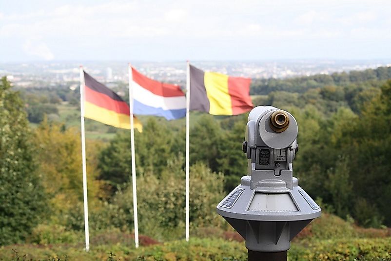Flags of the Netherlands, Belgium, and Germany where the three countries meet atop Vaalserberg Hill.