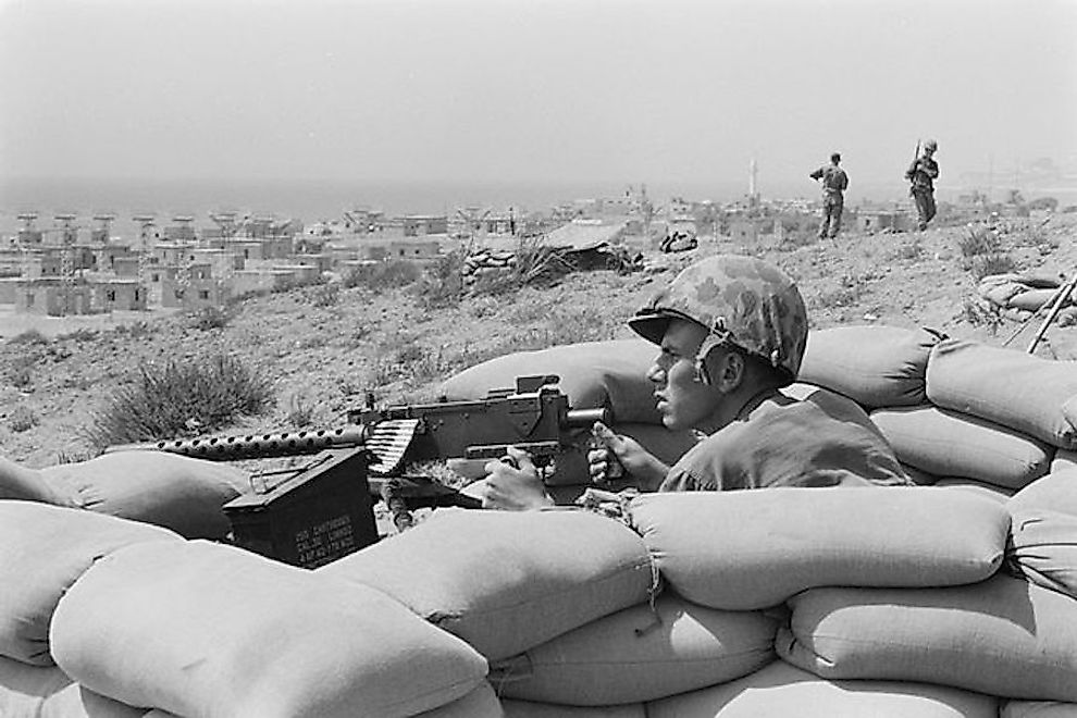 US Marine sits points a machine gun towards Beirut, Lebanon, in the distance.