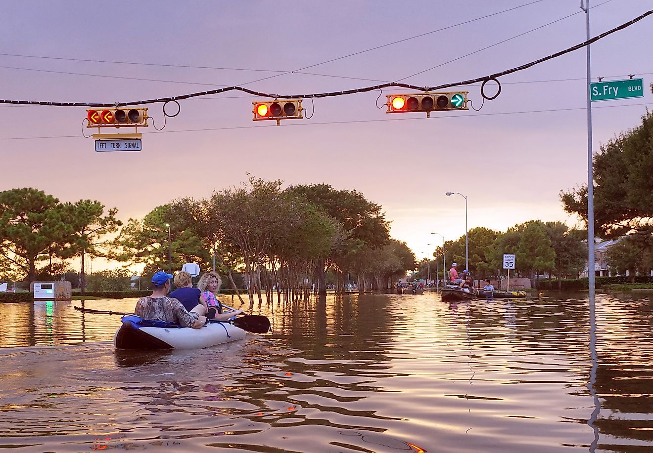 Traffic lights over flooded Houston streets and boats with people at sunset inTexas, USA. Image credit: Irina K/shutterstock.com