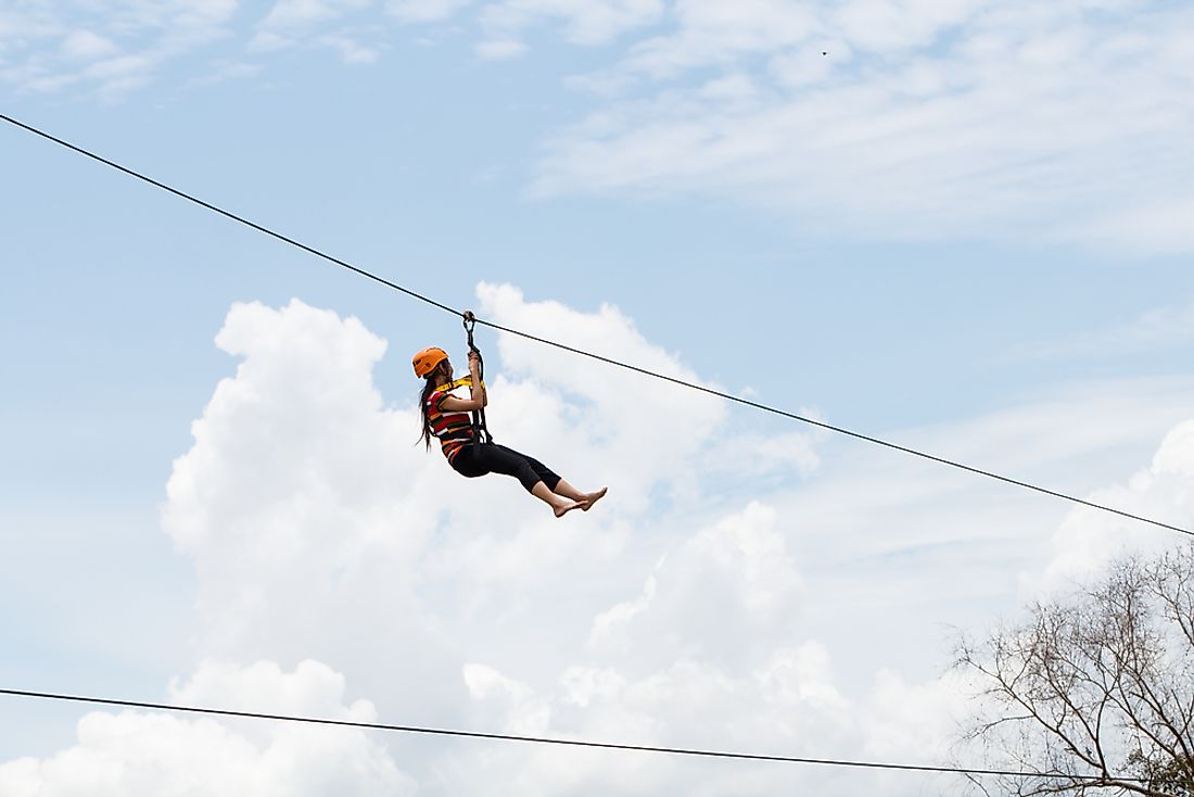 A woman rides on a zip-line. 
