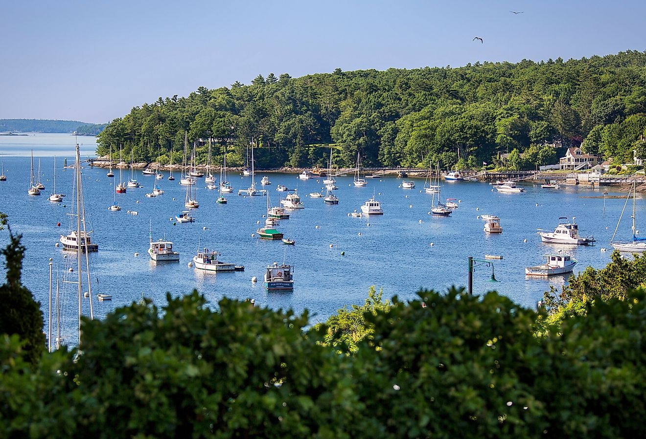 Sailboats and motorboats rest at anchor in Rockport Harbor, Maine, on a beautiful summer day.