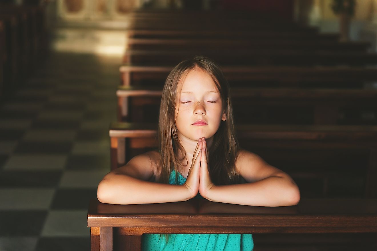 A child praying in church. Image credit: Anna Nahabed/Shutterstock.com