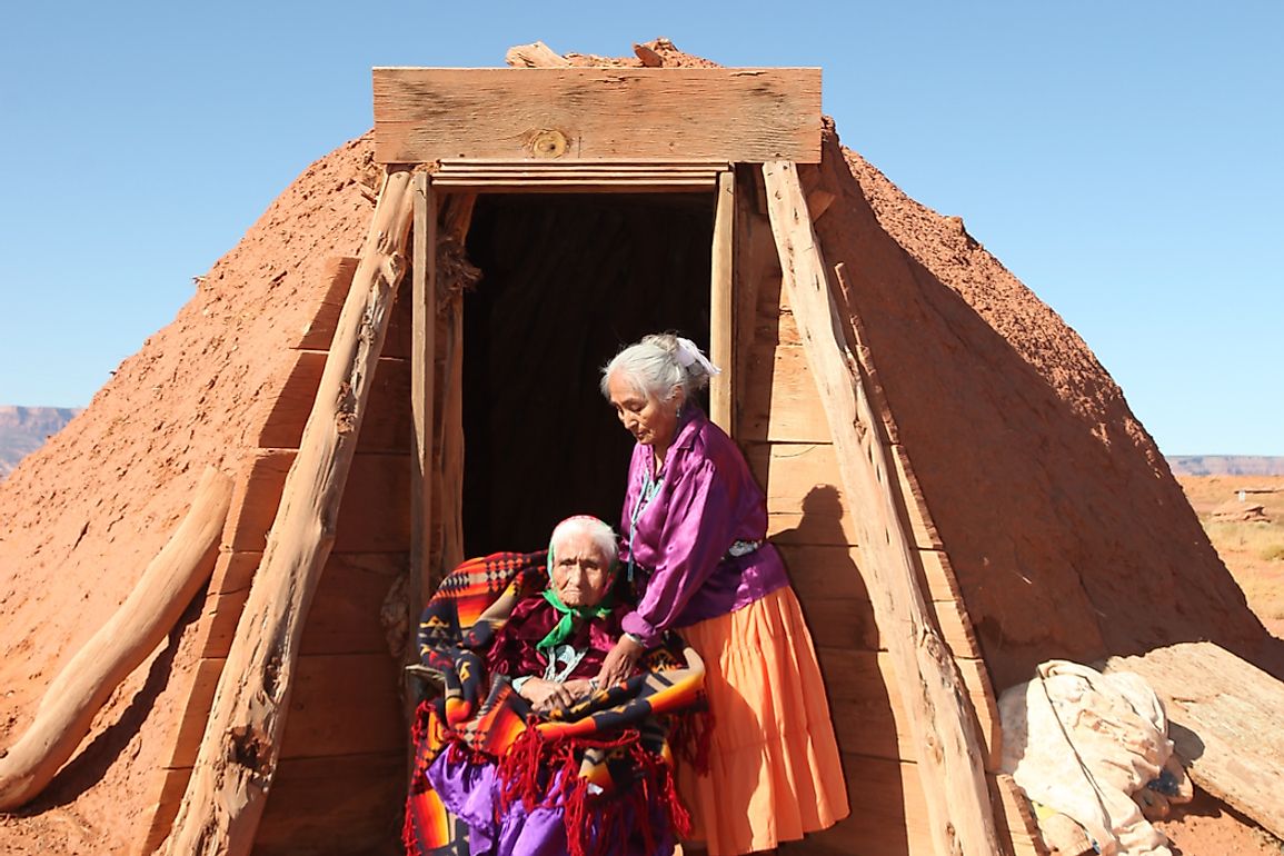Two Navajo women outside a hogan, the traditional dwelling of the Navajo. 
