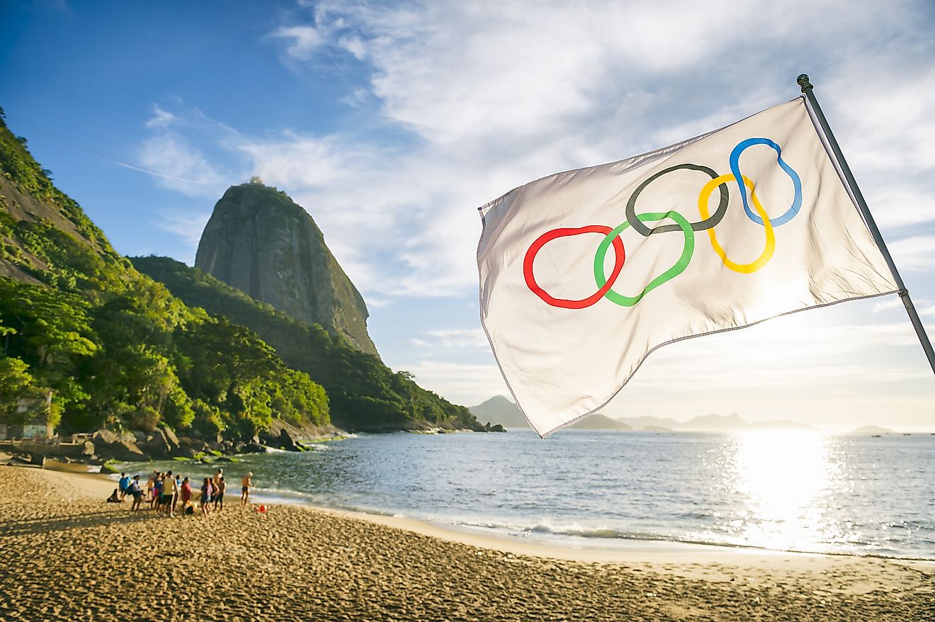 Olympic flag waves in front of the rising sun at Red Beach during the 2016 Summer Games.