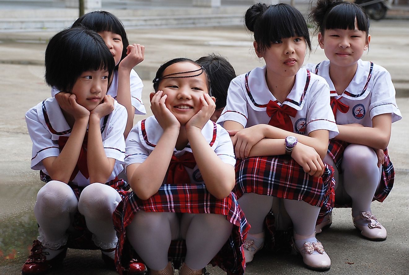 Group of Chinese school girls squatting in their school yard in Liuyang, China. Image credit: Drevs/Shutterstock.com