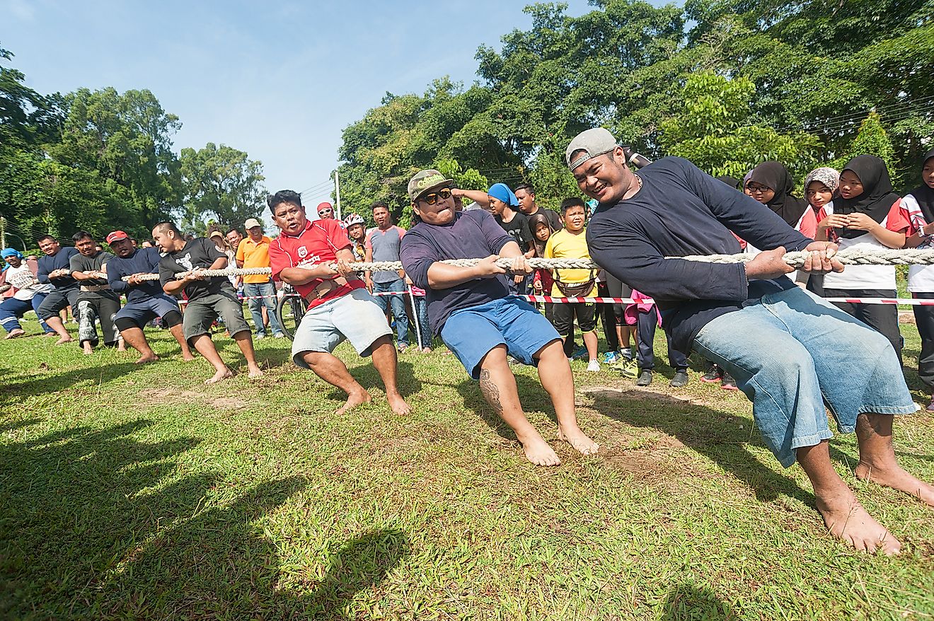 People participating in Tug Of War game during National Sports Day in Tuaran Public Field. Image credit: Lano Lan/Shutterstock.com