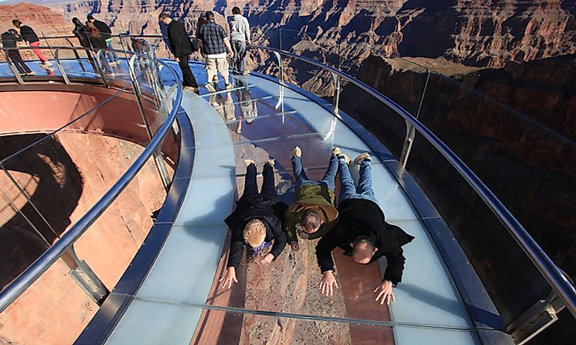 Visitors crawling along the skywalk at the Grand Canyon, one of the most thrilling skywalk experiences in the world.