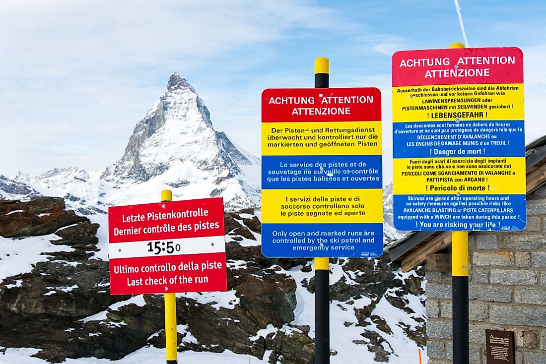 Signs in Switzerland using the country's three official languages. Editorial credit: Wirat Suandee / Shutterstock.com.