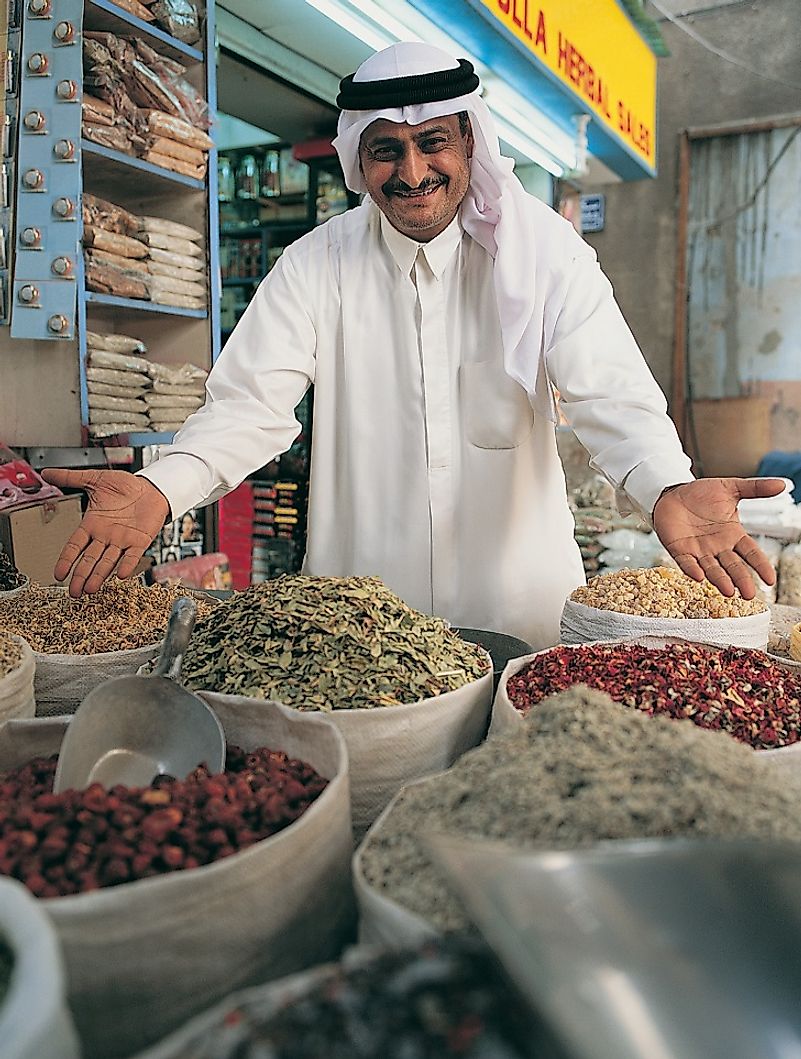 A vendor enthusiastically points out his goods in a souq in Dubai.