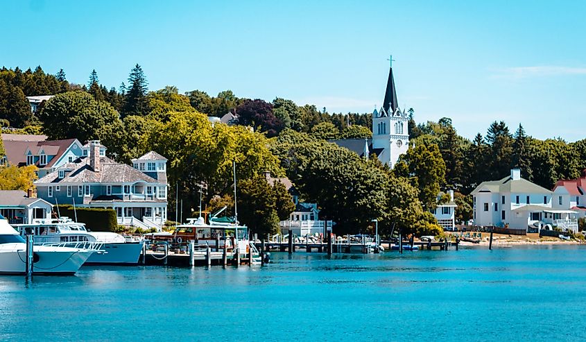 The Harbor at Mackinac Island with crystal blue waters, boats and a church steeple in the background