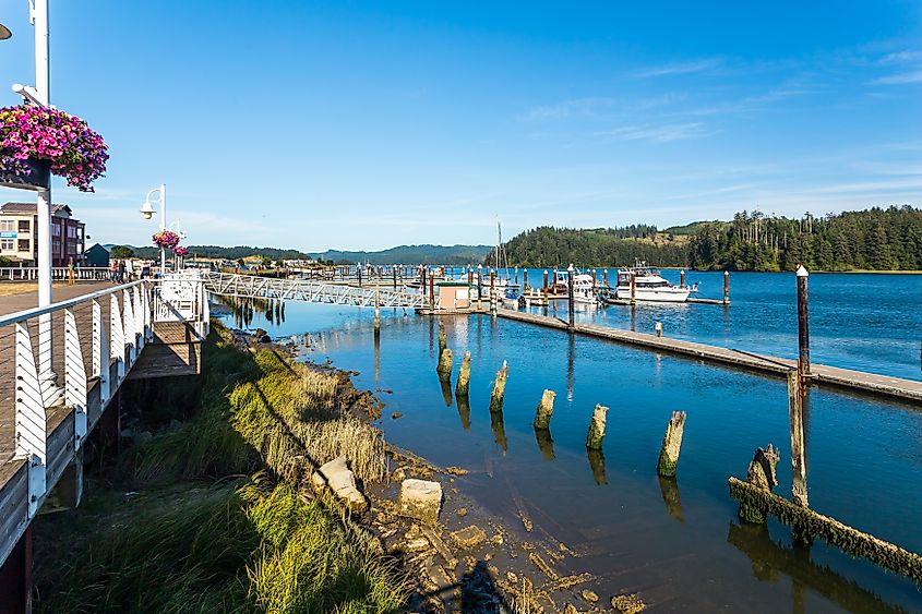 The riverwalk and boats lined along the Siuslaw River banks in Florence, Oregon.