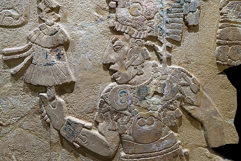 Maya bas relief carving in a stele tombstone of a Mayan king with staff of power in Palenque, Mexico.