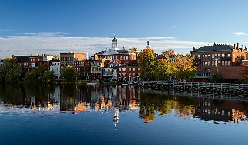 The riverfront buildings of Exeter, New Hampshire are seen reflected in the water