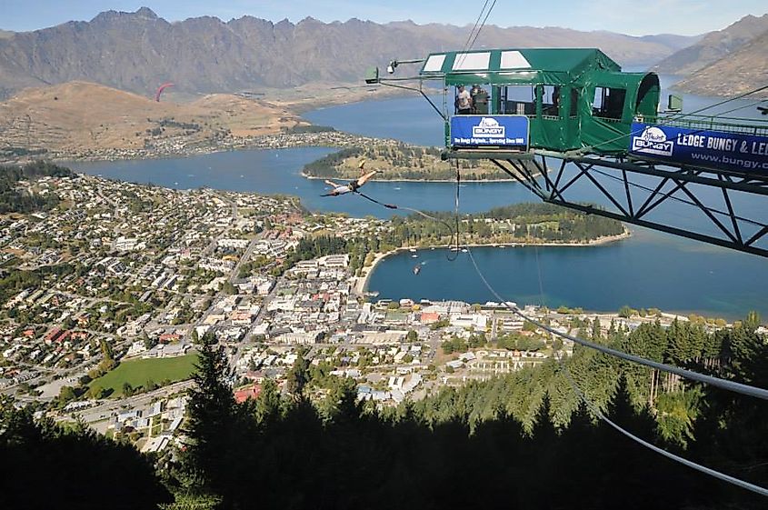 A man bungee jumps off of a mountainside platform, in Queenstown New Zealand.