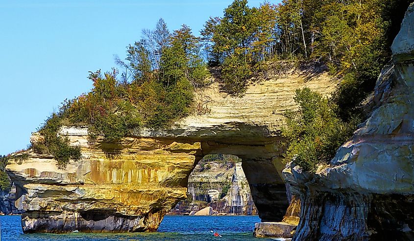 Kayaker heading for arch at Lovers' Leap in Pictured Rock Natural Lakeshore, MI