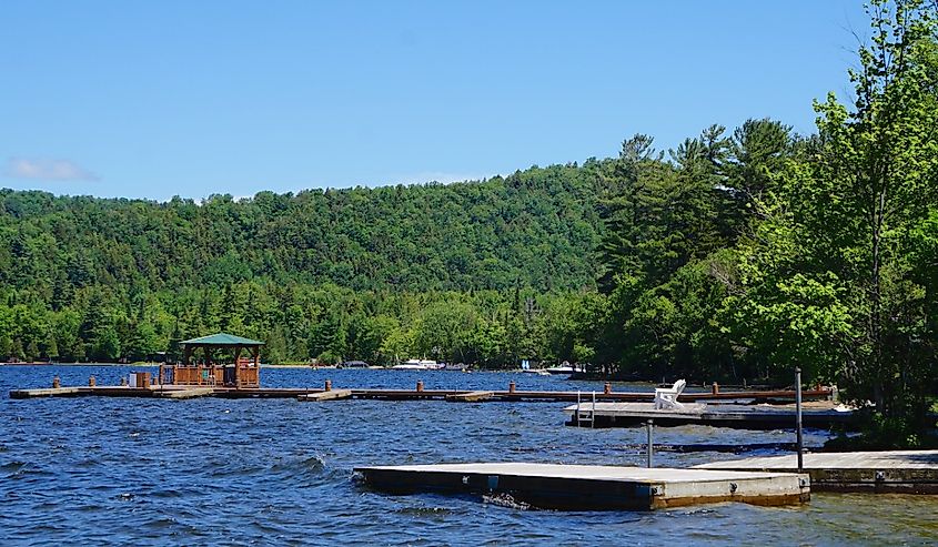 Wooden boat docks floating on the choppy water of Fourth Lake, located near the town of Inlet, New York.