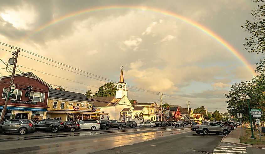 A rainbow over the shops, restaurants, and church of a New Hampshire tourist town, North Conway