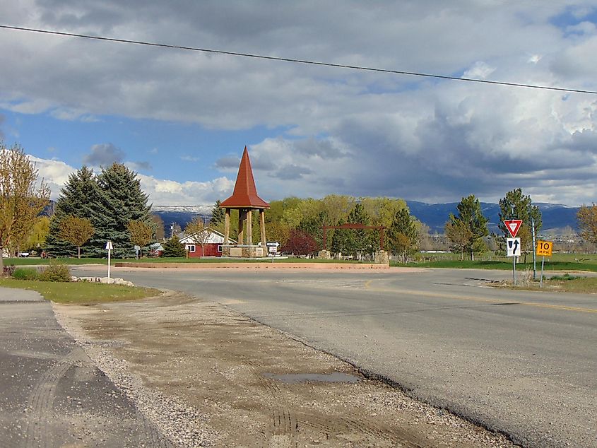 Looking east at a short bell tower within a roundabout at the east end of Burge Lane (East 1050 North), at its intersection with River Road, on the eastern border of Midway, Utah