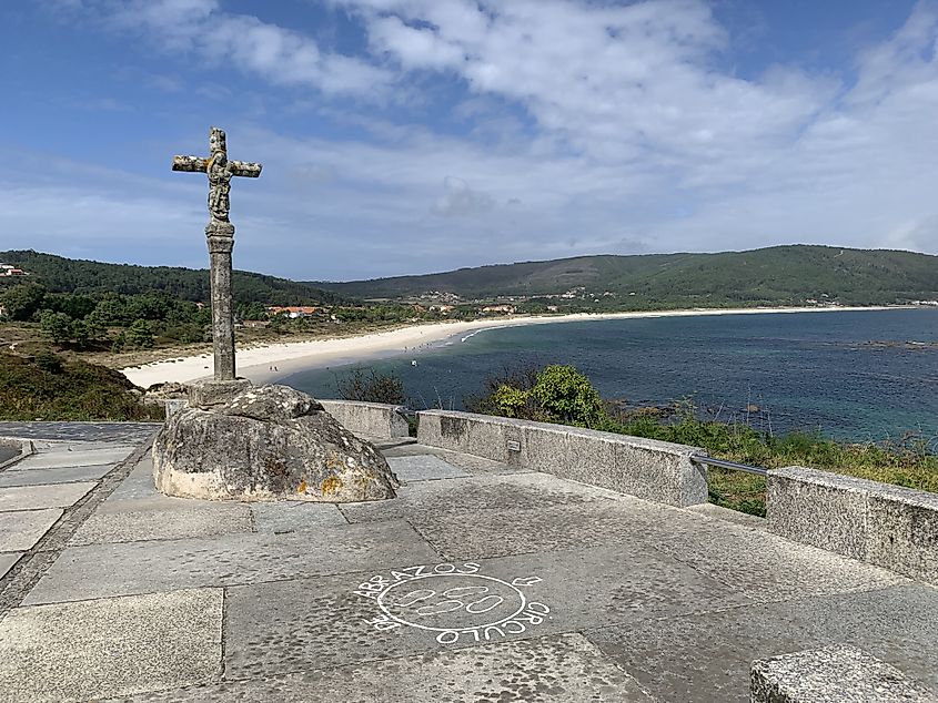A cross stands on a lookout overlooking a beautiful beach on the Atlantic Ocean.