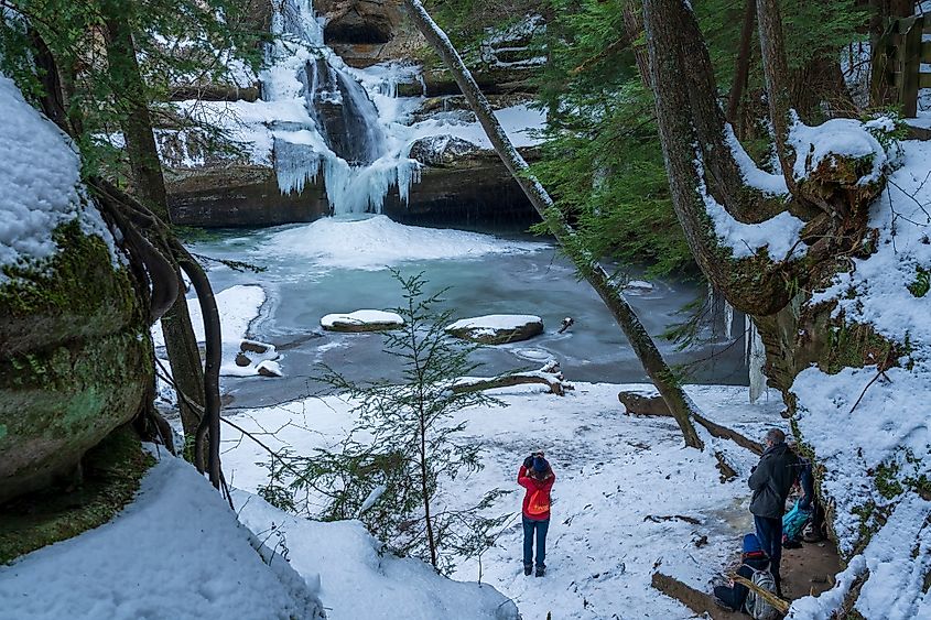 Hikers take in the winter view of Cedars Falls in Hocking Hills Ohio.