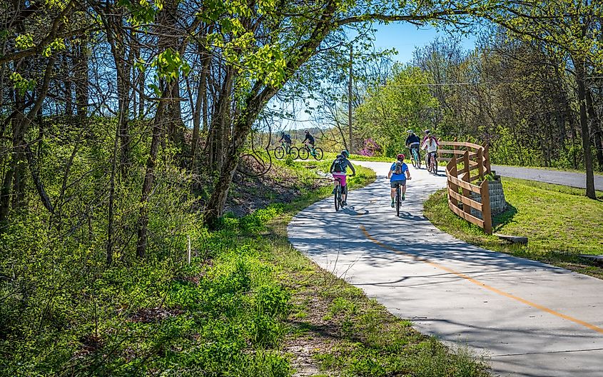 A family with kids is biking on a trail in Bella Vista, Northwest Arkansas.