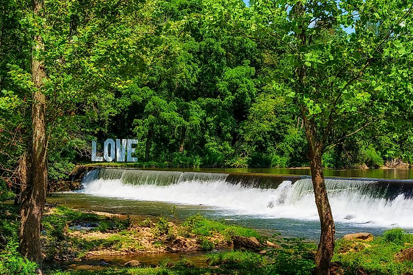 Damascus, Virginia: Love sign on the opposite New River bank from Old Mill Restaurant, at the end of a waterfall from a weir.