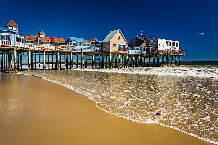 Scenic view of the Atlantic Ocean and the pier in Old Orchard Beach, Maine, under a clear blue sky.