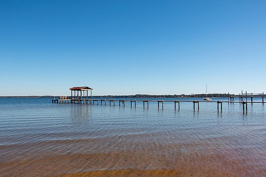Boat pier dock in Lillian, Alabama, with a tranquil setting under a blue sky.