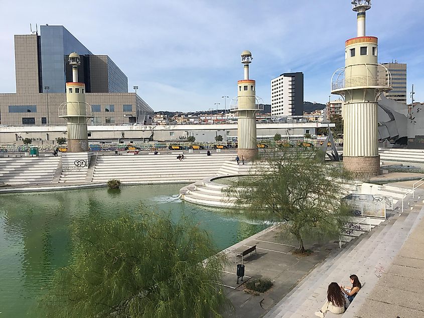 A large concrete city park with a watering hole, next to the Barcelona-Sants train station