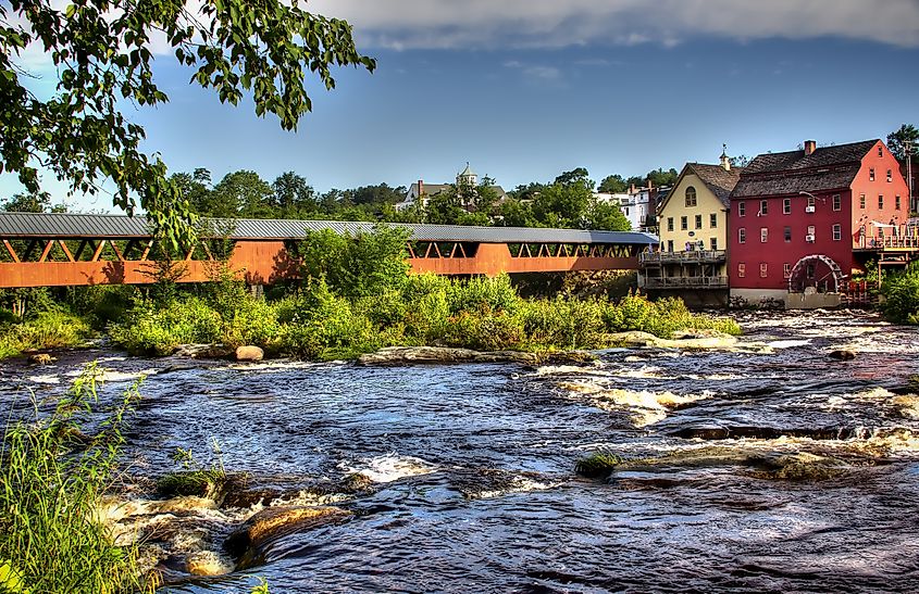 The River Walk Covered Bridge with the Grist mill on the Ammnosuoc River in Littleton, New Hampshire.