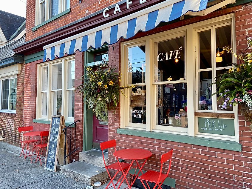 Exterior of a cafe with a striped awning and red tables and chairs in downtown Stroudsburg, Pennsylvania. Editorial credit: Here Now / Shutterstock.com