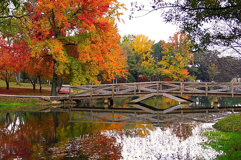 Scenic pond with a bridge surrounded by autumn foliage in Batesville, Arkansas.