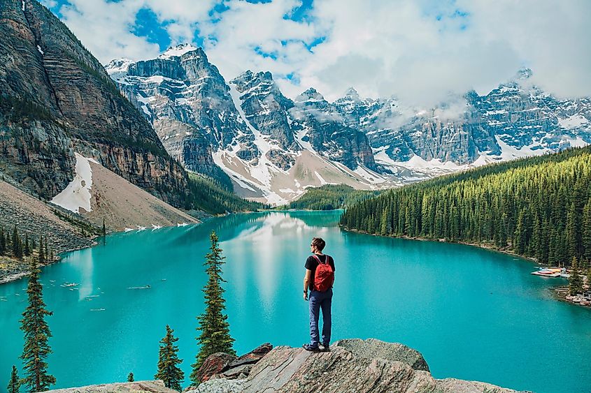 Hiker at Moraine Lake, Banff National Park, Alberta, Canada, surrounded by the Canadian Rockies landscape, carrying a backpack.