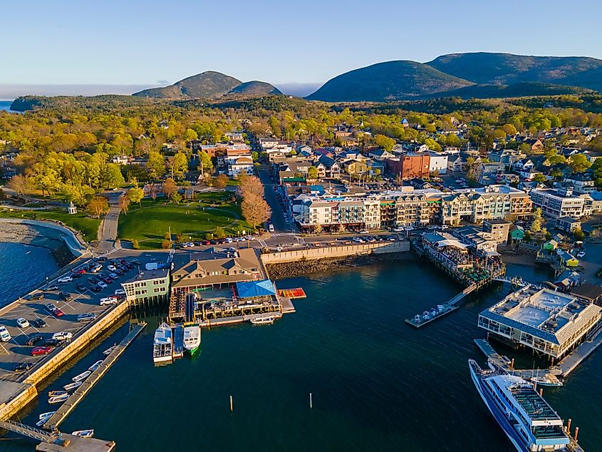 Bar Harbor historic town center aerial view at sunset, with Cadillac Mountain in Acadia National Park at the background, Bar Harbor, Maine, USA.