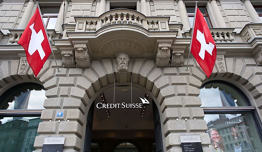 Entrance of historic bank building of Swiss bank Credit Suisse at Paradplatz (Parade Square) with Swiss flags at City of Zürich. 