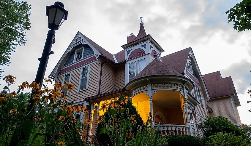 The Scandinavian Inn, a Victorian style Bed and Breakfast after sunset and flowers in garden, at dusk.